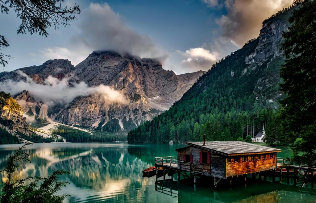 Peaceful mountain lake scene featuring a rustic boathouse and stunning reflections. Inno'van
